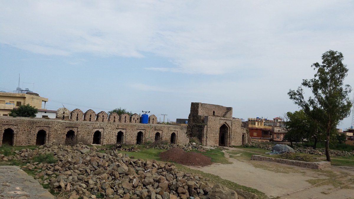 Courtyard of Rawat Fort with arched merchant cells and stone from restoration work