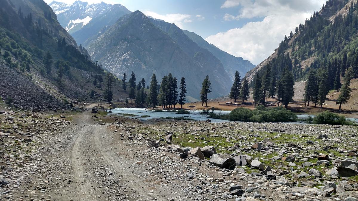 The jeep track to Mahodand Lake beside the Ushu river with pine forest and peaks