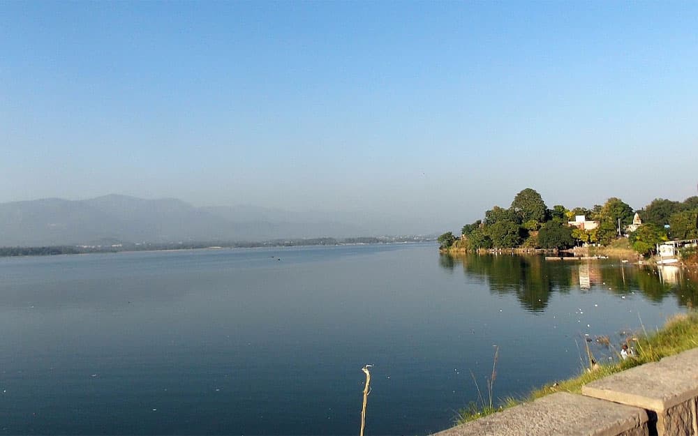 Boats on Rawal Lake with hills in the background, a short drive from LEORK Hotels Rawalpindi